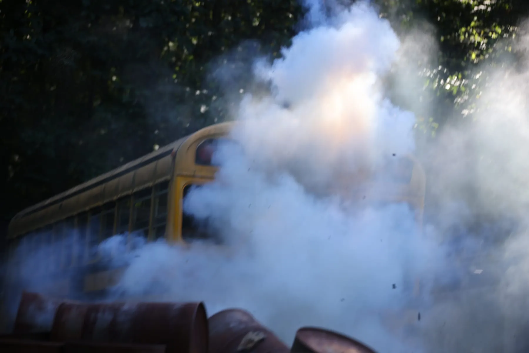 Smoke grenade exploding beside the bus