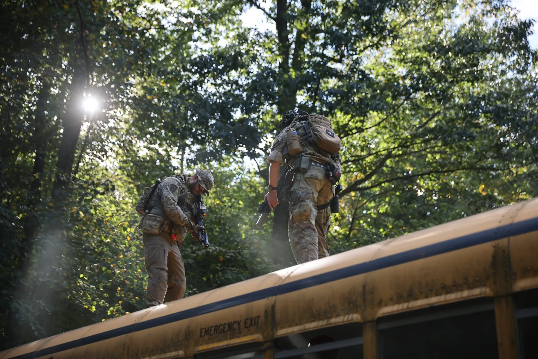 Players moving across the roof of a school bus in the sun